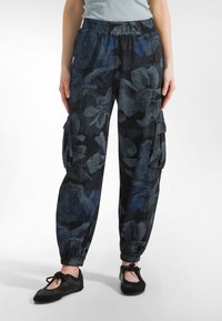 Sorte cargobukser med blomstermønster i blå og grå, med opsmøgede manchetter, elastisk talje og sidelommer. Blødt, åndbart stof.