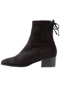 Bottine en daim noir avec un bout pointu et un talon bloc mi-hauteur, ornée d'un détail en lacet à l'arrière. Design simple et élégant.