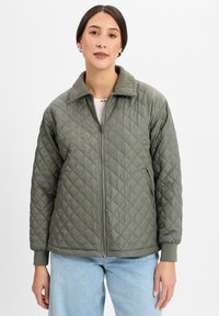 Gequilted olijfgroene jas met een rits aan de voorkant, gestructureerde kraag en ribgebreide manchetten. Heeft een ruitpatroon en een gladde textuur.