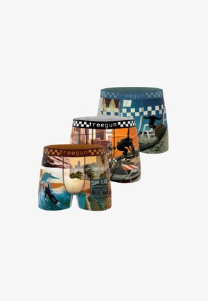 Trois paires de boxers Freegun colorés avec des scènes de surf et de skateboard, avec des ceintures à carreaux noires, bleues et marron.
