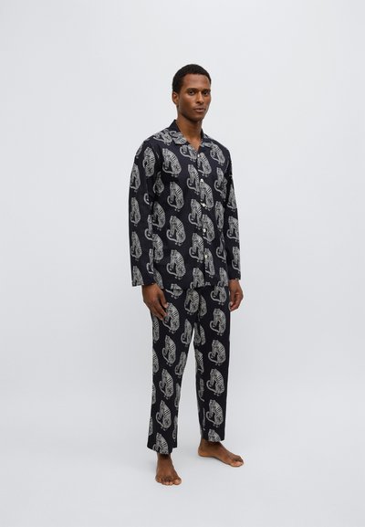 Completo pigiama blu navy con motivi di tigri bianche, realizzato in tessuto leggero. Maglia a maniche lunghe e pantaloni ampi con design confortevole.