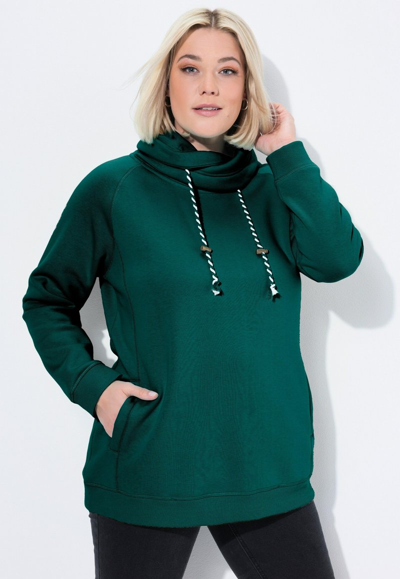 Felpa verde con cappuccio, collo a barchetta, cordini, tasche frontali e polsini a costine. Texture morbida, vestibilità casual e maniche lunghe.