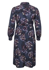 Marineblauwe bloemenjurk met lange mouwen, voorzien van een kraag en een strik taille. Het ontwerp bevat grote paarse en romige bloemen op een donkere achtergrond.