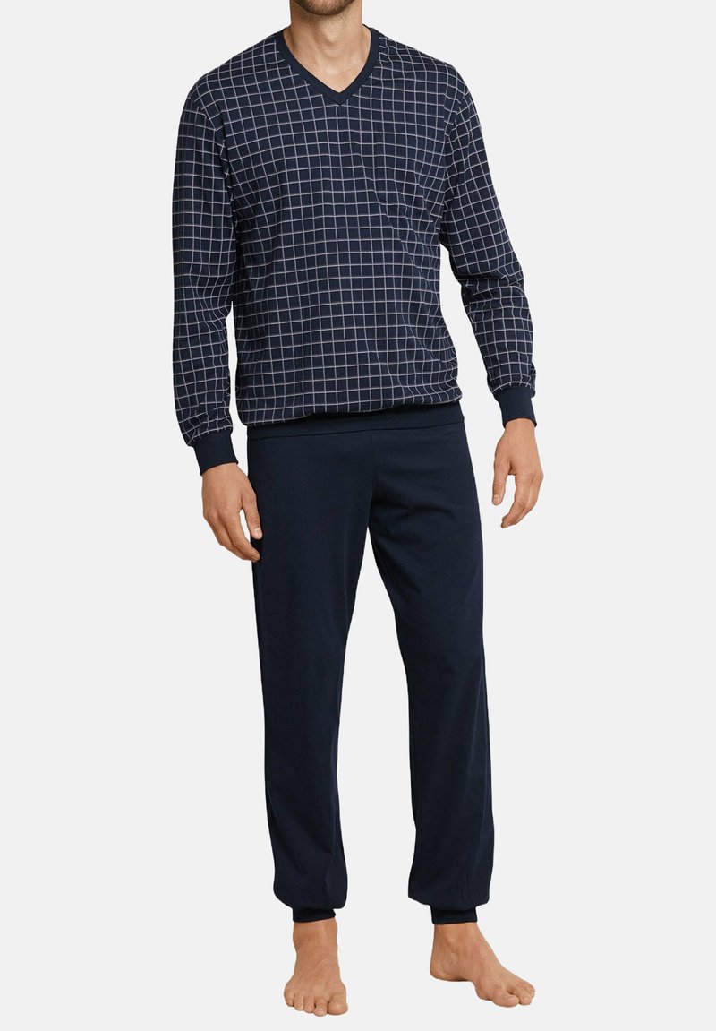 Conjunto de loungewear en navy que incluye una parte superior de manga larga con escote en V y un patrón de cuadrícula blanca, junto con pantalones lisos, fabricado en un tejido suave y ligero.