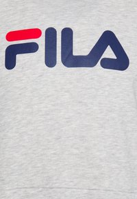Felpa grigia chiara con un grande logo blu navy "FILA" e un accento rosso sopra la lettera "F". Texture morbida e design classico con collo a girocollo.