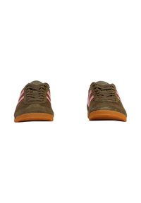 Braune Wildleder-Sportschuhe mit pinken Streifen und beigen Akzenten; verfügen über eine Gummisohle und beige Schnürsenkel; flaches Design, minimalistischer Stil.