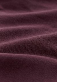 Material moale, de un violet profund, cu pliuri fine și o suprafață netedă, ușor texturată.