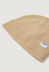 Kübej kootud beanie, millel on sooniktekstuur, volditud äär ja külje peal väike sinine "HUGO" sildi logo. Pehme kangas, ilma mustrita.
