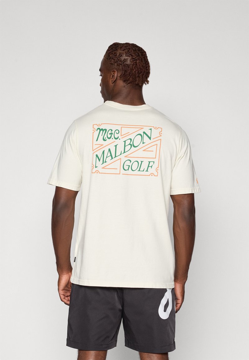 Kremo spalvos medvilnės marškinėliai su spalvinga „M.G.C. MALBON GOLF“ grafika nugaros pusėje, trumpomis rankovėmis ir laisvu siluetu.