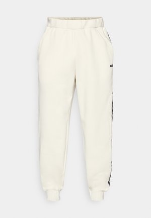 Cremefarvede sweatpants med elastisk talje, tætsiddende manchetter og sorte sideaccenter. Fremstillet af et blødt, tekstureret stof.