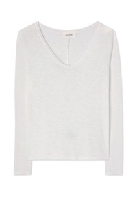 Valge pika varrukaga naiste pluus süvendi kaelusega ja kergelt tekstuurse kangaga, asetatud valgele taustale laiali laotatuna.