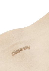 Beige stof met een gladde textuur, met het woord "dichtbij" in een subtiele metallic afwerking. Zacht en minimalistisch ontwerp.