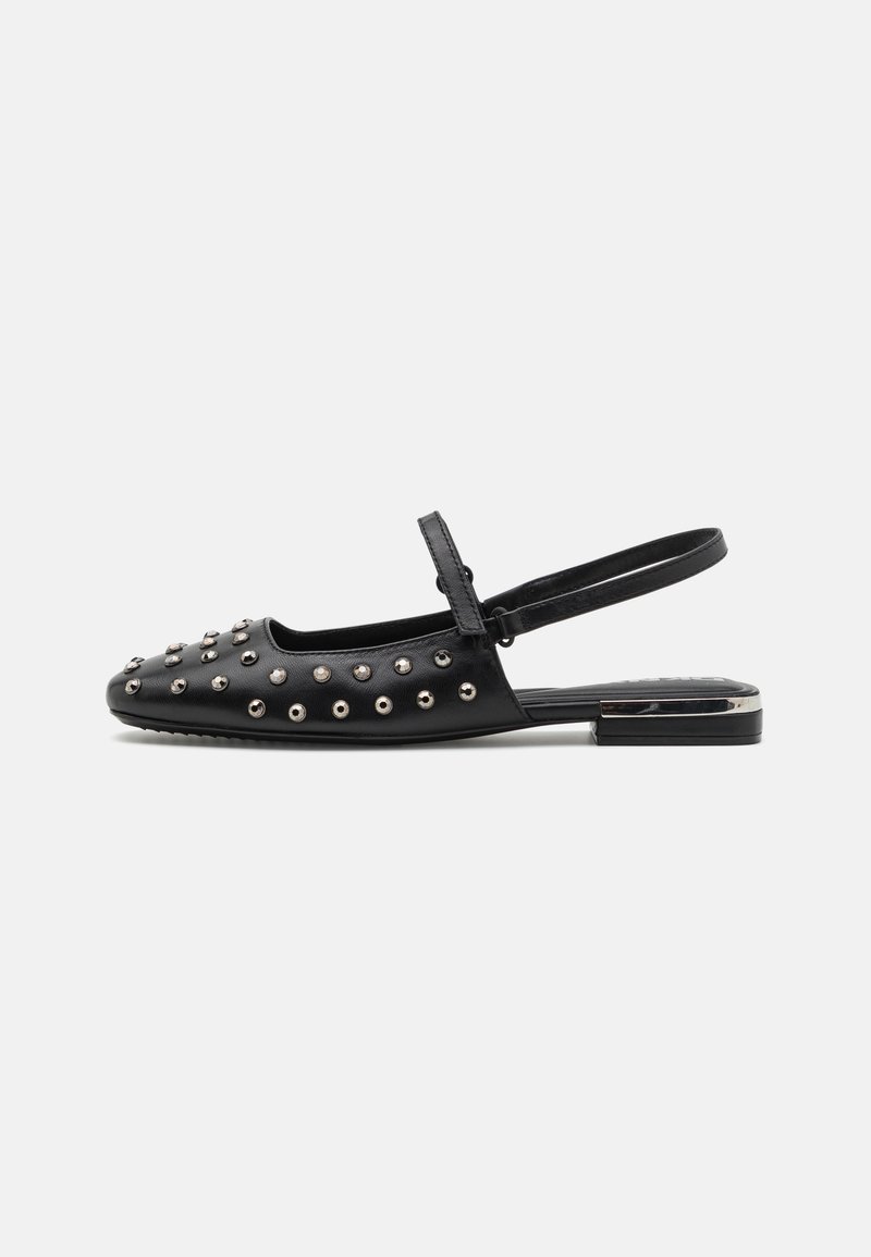 Crna slingback cipela od kože, s metalnim šiljcima na gornjem dijelu, ravnim potplatom i podesivim remenom za prilagodbu i udobnost.