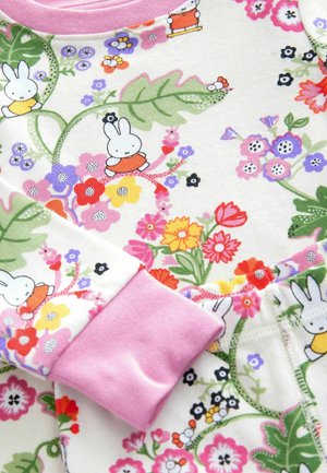 Korte mouwen kledingstuk met een witte basis, gekenmerkt door kleurrijke bloemenpatronen en speelse konijnenillustraties. Roze geribbelde manchetten voegen detail toe.