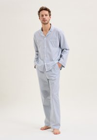 Completo pigiama in cotone a righe azzurro chiaro con bottoni, una tasca sul petto e maniche lunghe. I pantaloni hanno una vita elastica.