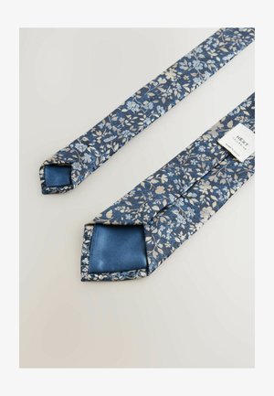 Blomster slips i blå med lyseblå og beige mønstre. Fremstillet af stof med satin finish, med en spids ende og et mærke.