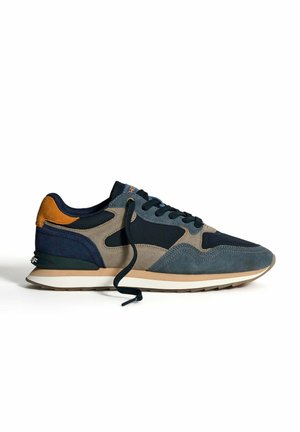 Legere Sneaker in Marineblau, Grau, Beige und Orange mit Wildleder-Einsätzen, schwarzen Schnürsenkeln und einer weißen und braunen Gummisohle, fotografiert vor einem weißen Hintergrund.