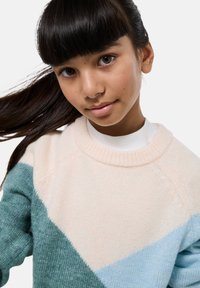 Pull en tricot avec un design géométrique en blocs de couleur crème, sarcelle et bleu clair. Texture douce avec un col rond côtelé.