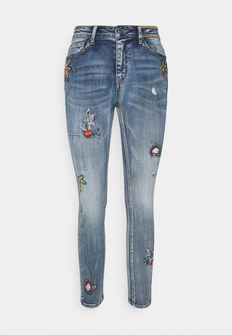 Modré džíny skinny z denimové látky s různými výšivkami květin a ovoce, s mírným blednutím a děravými záplatami na nohavicích.