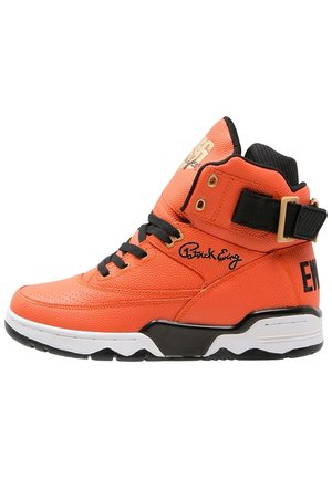 Baskets montantes oranges avec lacets noirs, semelle noire et blanche, une sangle noire avec boucle et la signature "Patrick Ewing" sur le côté.