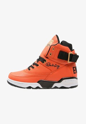 Baskets montantes oranges avec lacets noirs, semelle noire et blanche, une sangle noire avec boucle et la signature "Patrick Ewing" sur le côté.