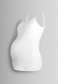 Balta grūtniecības blūze ar regulējamām siksniņām, izgatavota no elastīga auduma, izstrādāta, lai pielāgotos augošai vēderam ar pieguļošu siluetu.