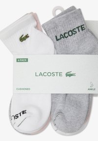 Lacoste ankle socks in a 6-pack featuring white, gray, and pink colors with a green embroidered logo and branding on the cuffs.