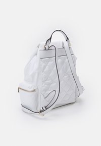 Mochila blanca acolchada de nailon, con un bolsillo lateral con cremallera, ribete negro y correas ajustables. Textura suave.