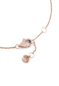 Řetízek ve zlaté růžové barvě s karabinkou a malou kulatou značkou s vyrytým nápisem na bílém pozadí, ukazujícími detaily zavírání šperků.