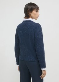 Navy-blauer Strickpullover mit geripptem Muster, überschnittenen Schultern und leicht verkürztem Schnitt. Besitzt dezente mehrfarbige Einsprengsel.
