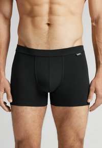 Svarta kalsonger för män i boxerstil, tillverkade av mjukt, stretchigt tyg. Har en tätt sittande design med en bred midjeresår och en framficka, samt minimala sömmar.