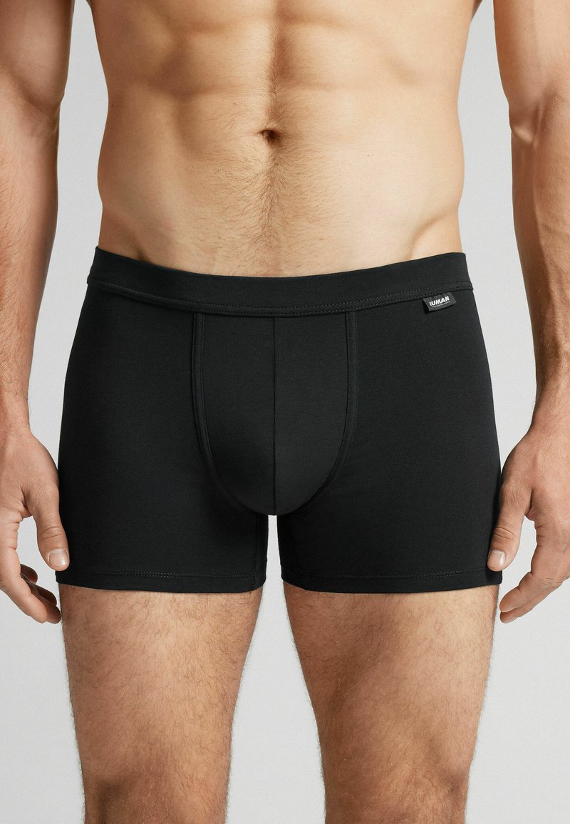 Svarta kalsonger för män i boxerstil, tillverkade av mjukt, stretchigt tyg. Har en tätt sittande design med en bred midjeresår och en framficka, samt minimala sömmar.