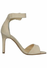 Béžové zamšové sandále na vysokom podpätku s otvorenou špičkou, zakriveným remienkom na členku a štíhlym stiletto podpätkom. Hladká textura a minimálne detaily dizajnu.