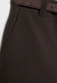 Pantaloni marrone scuro a righe sottili con tasca laterale e cintura marrone abbinata con dettagli realizzati a punto.