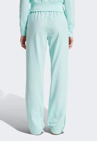 Mintgroene sportbroek met een relaxed fit, voorzien van een elastische tailleband en boorden, gemaakt van gladde, lichte stof.