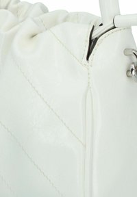 Bolso de cuero sintético blanco con parte superior arrugada. La superficie texturizada presenta patrones diagonales cosidos. El herraje plateado resalta el diseño.