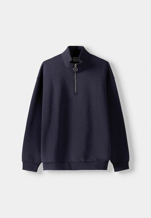 Marineblaues Sweatshirt mit hohem Kragen und halber Reißverschlussöffnung. Es verfügt über gerippte Bündchen und Saum, eine glatte Textur und ein minimalistisches Design.
