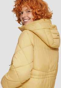 Geel pufferjack met capuchon, voorzien van een diamanten quiltpatroon en elastische manchetten. Glad textuur, lichtgewicht ontwerp. Met ritszakken.
