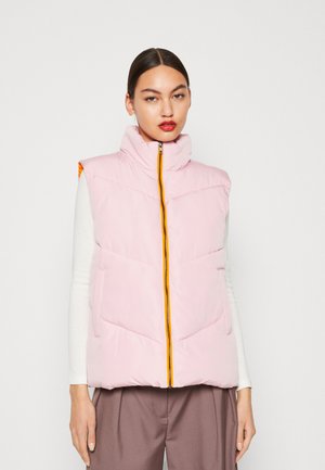 Rosa Steppweste mit Stehkragen, orangefarbigem Reißverschluss und zwei Fronttaschen. Sie hat ein gestepptes Design und wird über einem weißen Langarmshirt getragen.