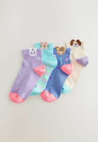 Vier kleurrijke kindersokken met dierengezichten: konijn, kat, beer en hond, met strepen, hartjes en stippen.