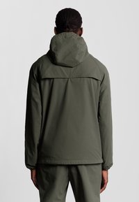 Giacca con cappuccio verde oliva dal design minimalista, caratterizzata da una vestibilità dritta e polsini elastici. Tessuto liscio e senza motivi visibili.