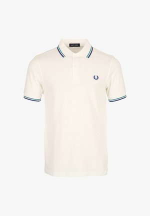 Camiseta tipo polo blanca de manga corta con cuello y bordes de las mangas a rayas azules y verdes, con un pequeño logotipo azul de laurel en el pecho.