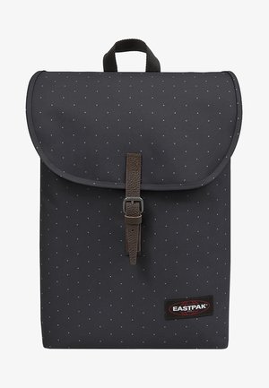 Czarny plecak z tkaniny z klapką, ozdobiony małymi białymi kropkami, z brązowym paskiem ze skóry oraz metką z logo Eastpak.
