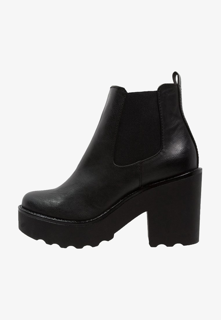 Bottine en cuir noir avec talon haut épais, panneau latéral élastique et languette arrière pour un enfilage facile.
