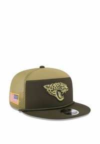 Die Kappe hat ein Design in Olivgrün und Khaki, einen flachen Schirm, ein eingesticktes Jaguar-Logo, strukturierte Seitenpanels und ein kleines Patch mit der amerikanischen Flagge.