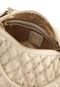 Interno della borsa a tracolla beige trapuntata con una cerniera color oro, rivestimento in satin con motivo logo e una piccola tasca con cerniera.
