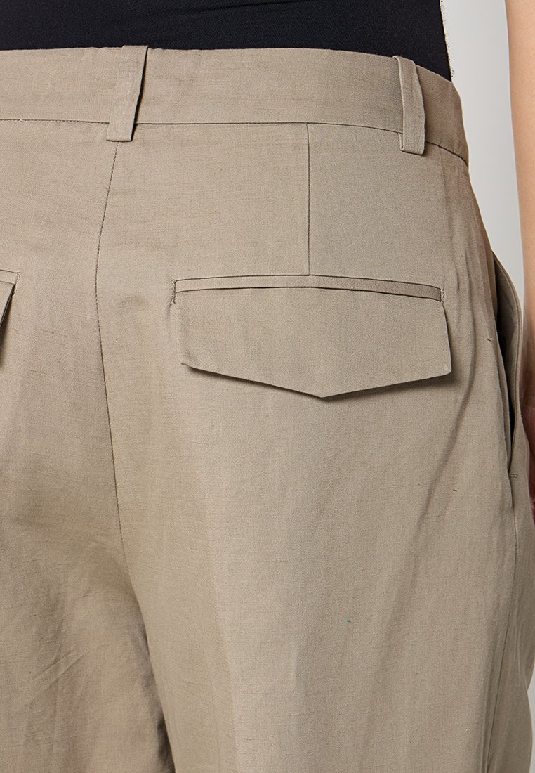 Beige linnenbroek met een gladde textuur, voorzien van dubbele achterzakken en een op maat gemaakte pasvorm, die een strakke, eigentijdse uitstraling benadrukt.