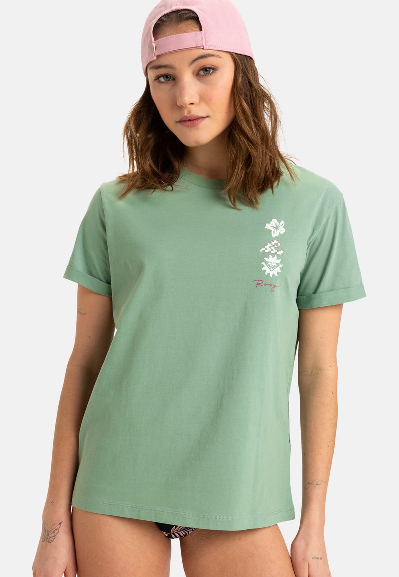 Grøn bomulds T-shirt med optrækning af ærmerne, prydet med blomster grafik og teksten "Roxy" i en kontrastfarve på forsiden.