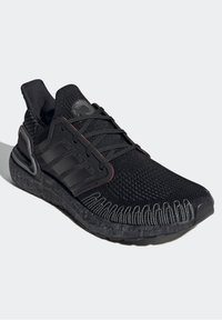 Sneaker athletic nera con tomaia in maglia, suola testurizzata, dettaglio a tre strisce e punta rotonda con collo imbottito.