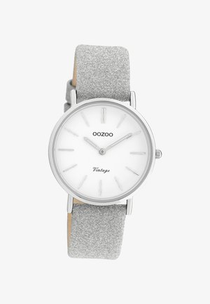 Montre-bracelet OOZOO Vintage argentée avec un cadran blanc, des index minimalistes et un bracelet argenté scintillant affichant l'heure 10h10.